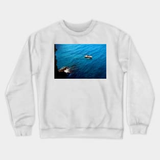 View from a high rocky shore of Polignano a Mare at a boat in the Adriatic sea Crewneck Sweatshirt